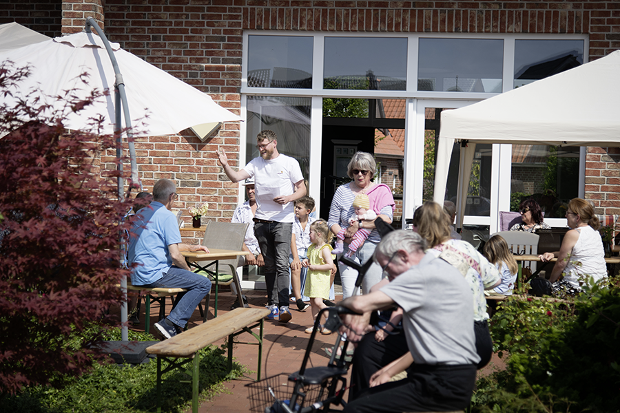 Bewohner und Familienmitglieder sitzen auf der Terrasse