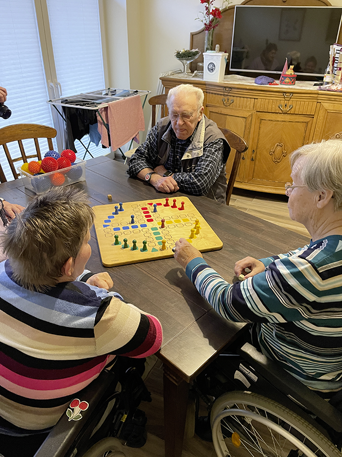 3 Personen spielen ein Brettspiel